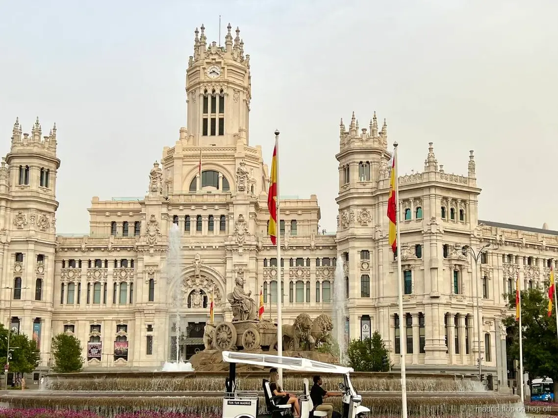Zweisprachiger Guide fährt ein Elektro-Tuk-Tuk durch Madrid