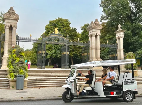 Tuk tuk elèctric aturat prop d'un monument de Madrid per fer fotos